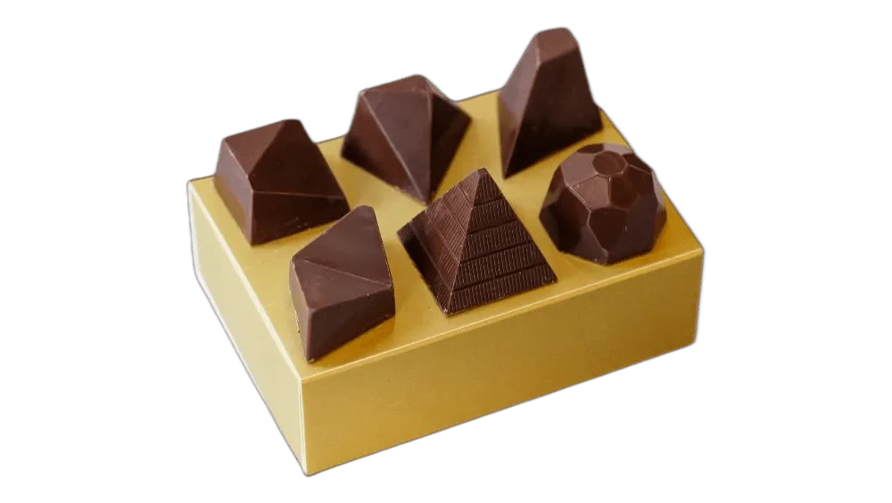 Six gem-shaped chocolate pralines on a golden box